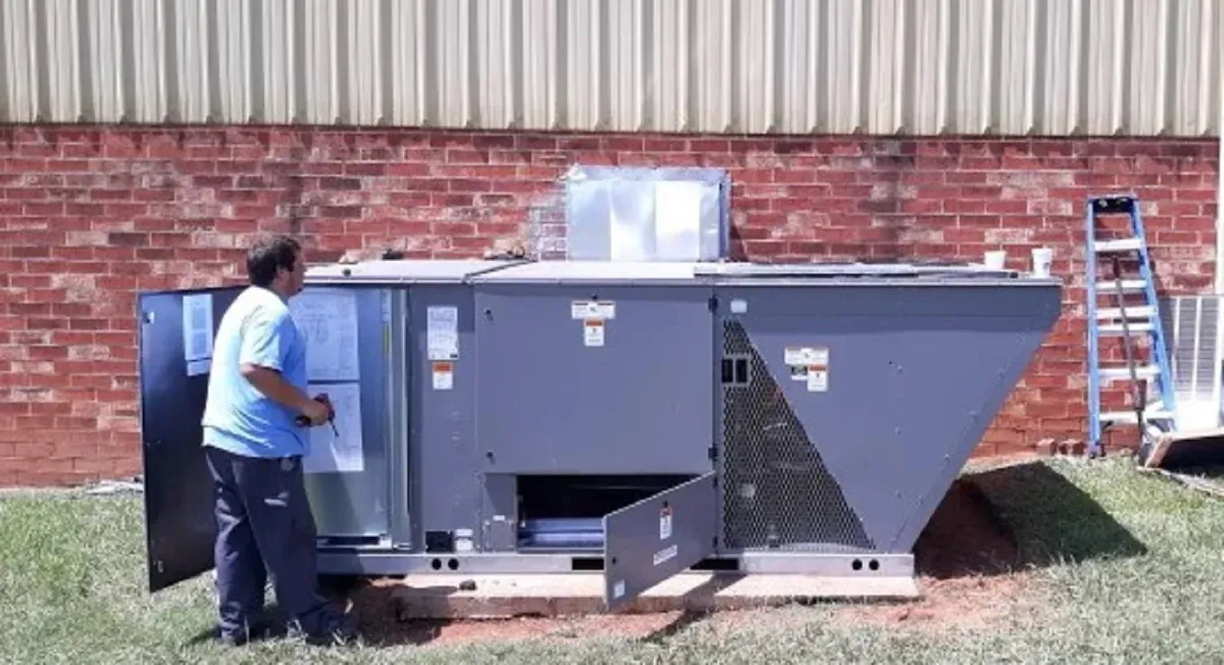 Prepare Your AC for Summer: Spring Tune-Up Guide 2 Technician inspecting an air conditioning unit during a professional tune-up