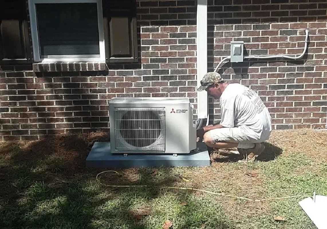 Why Is My AC Not Cooling? Troubleshooting Guide 3 Technician holding a clean air filter next to an air conditioning unit